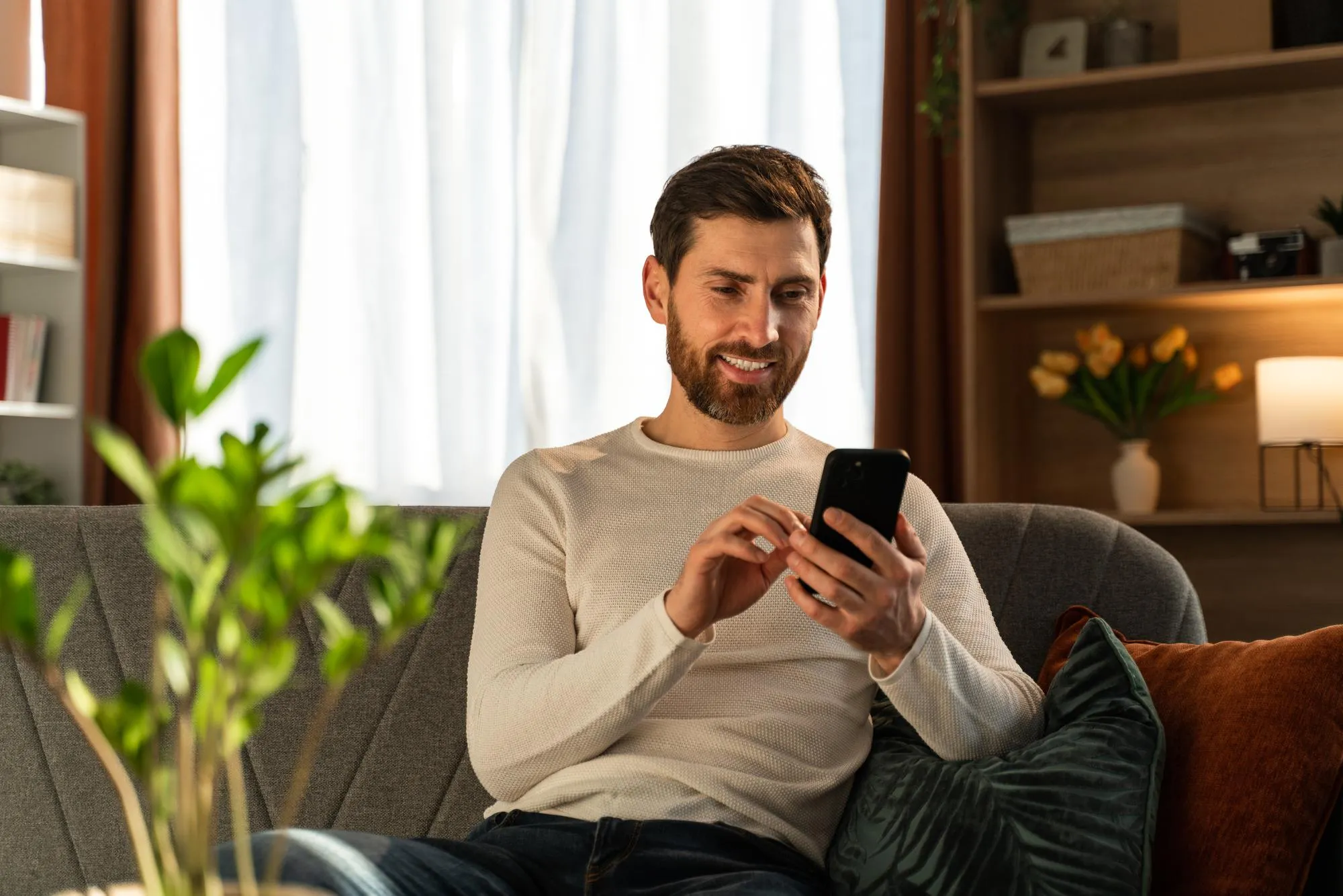 A man reviewing his rent plan on his phone at home