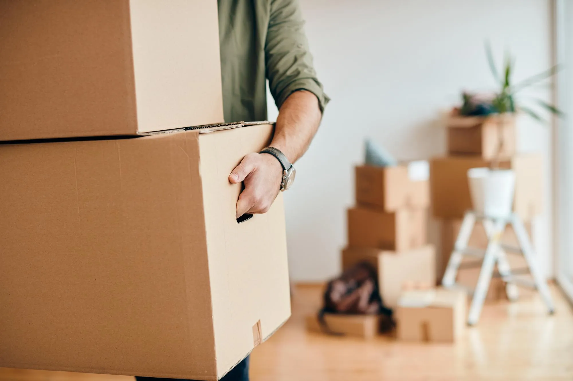 Someone stacking cardboard boxes while moving home